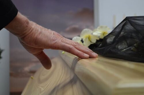 hand touching coffin