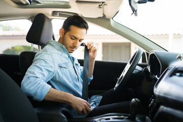 man putting on seatbelt in the car