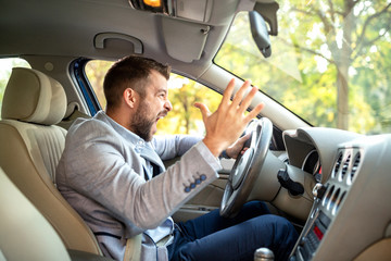 man with road rage screaming in car