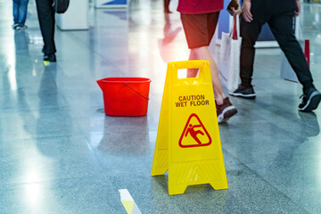 wet floor sign and people walking