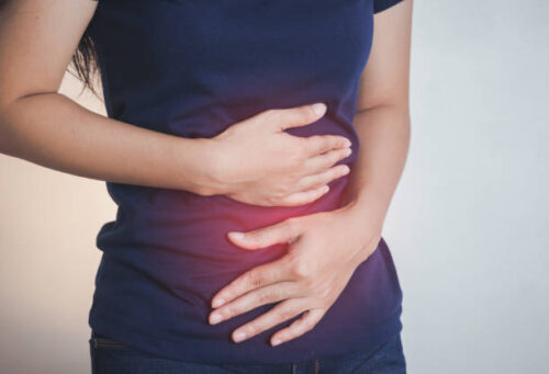 woman holding her stomach with red mark showing abdominal pain