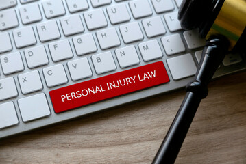 A computer keyboard with a red key labeled "PERSONAL INJURY LAW," highlighting personal injury and wrongful death cases, with a judge’s gavel resting nearby.