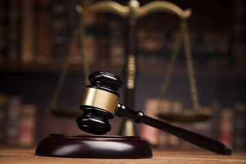 A judge’s gavel rests on a sound block in the foreground, with a blurred scale of justice and bookshelves in the background, evoking courtroom scenes involving cases like gross negligence car accident lawsuits.